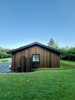 Ein Holzhaus mit schrägem Dach, kleinem Fenster und einer Tür.