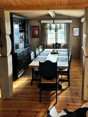 Une salle à manger avec une table en bois, des chaises et un buffet.