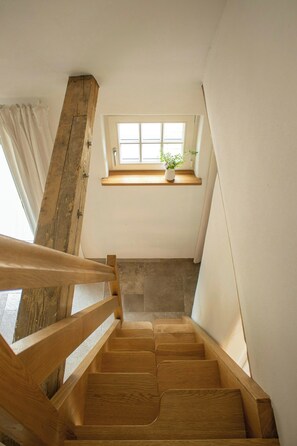 Eine Holztreppe mit einem Fenster oben.