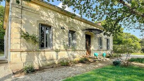 A stone building with a front door, windows, and a small porch area. - American-style villa with pool in Montalivet (Vendays-Montalivet)