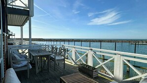Eine Terrasse mit einer weißen Couch, einem kleinen Tisch und einem Stuhl.