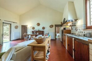A spacious kitchen with a dining area, wooden cabinets, and a large window. - Restored barn with views of Siena countryside (Castelnuovo Berardenga)