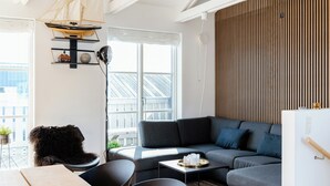 A modern living room with a gray sofa, a wooden dining table, and a black chair. - Maritime atmosphere in Holiday Island (Ebeltoft)