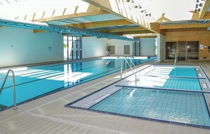 Ein Schwimmbecken mit mehreren Bahnen, einem Umkleideraum und einer Holzkonstruktion.