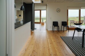 A modern interior with a kitchen, dining area, and large windows. - View over Aarhus bay from striking architecture (Egå)