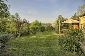 A grassy outdoor area with a wooden fence, a pergola with a canopy, and a building with a tiled roof. - Villa with views of Ostra and Marche countryside (Ostra)