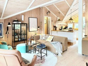 A cozy living room with a sofa, a coffee table, and a bookshelf. - House in the heather with sea view on Odden (Sjællands Odde)