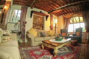 Ein gemütliches Wohnzimmer mit einer Couch, einem Sessel und einem Couchtisch.