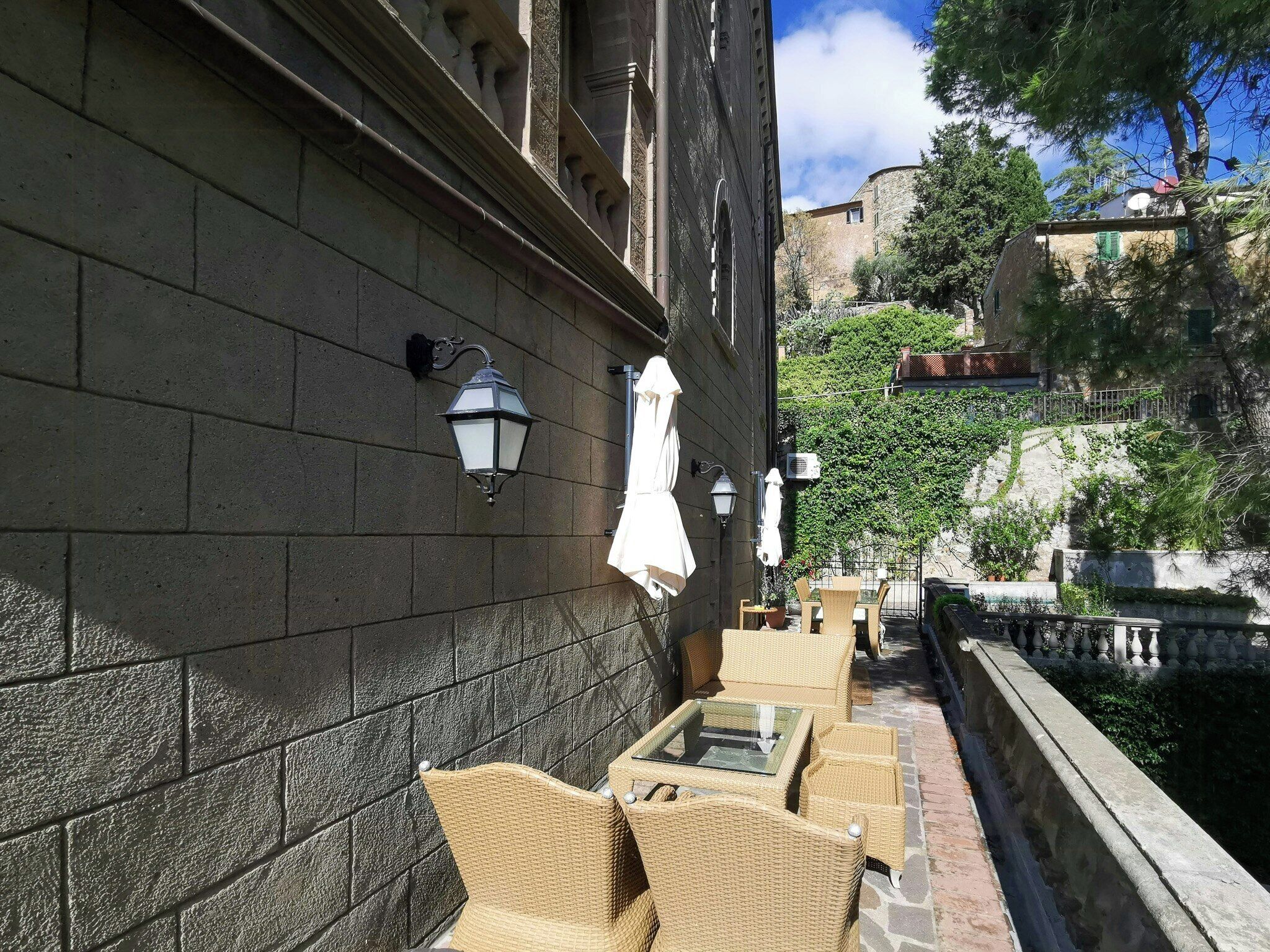 Outdoor wicker furniture, a stone wall, and a narrow water channel.