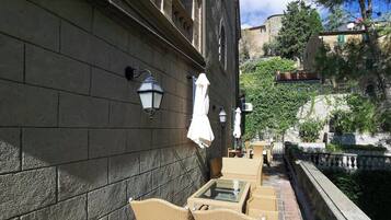Outdoor wicker furniture, a stone wall, and a narrow water channel.
