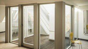 A room with a skylight, a chair, and a staircase leading to an outdoor area. - Wide view on nature from the manor house on Rügen (Poseritz)