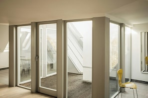 Ein Zimmer mit einer Dachfensterkuppel, einem Stuhl und einer Treppe, die in einen Außenbereich führt.