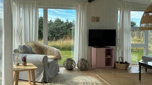A living room with a sofa, TV, and large windows. - Idyllic holiday home charm in Nr. Lyngby (Løkken)