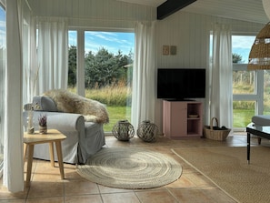 A living room with a sofa, TV, and large windows. - Idyllic holiday home charm in Nr. Lyngby (Løkken)