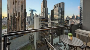A balcony with a view of a cityscape, including high-rise buildings and a clear sky. - Exclusive Stays - Southbank Grand (Southbank)