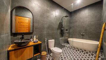 Un baño moderno con un espejo grande, un tocador de madera, un lavabo, un inodoro, una ducha y una bañera.
