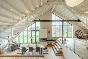 Ein großzügiger Loft mit hohen Decken, großen Fenstern, einem Essbereich und einer gemütlichen Sitzecke.