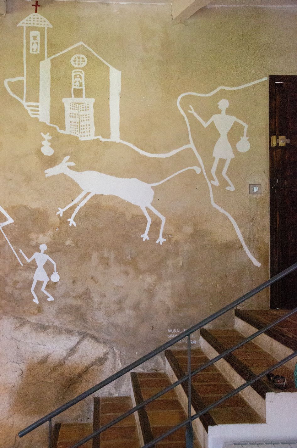 Ein Wandgemälde zeigt eine Kirche, ein Känguru und eine Person auf einer Treppe.