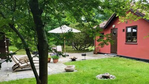 A red building with a patio area, outdoor seating, and a fire pit. - Lovely summerhouse by Sejerø Bay (Vig)