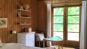 A wooden room with a bed, a dresser, a chair, a table, and a window with curtains. - Lovely summerhouse by Sejerø Bay (Vig)