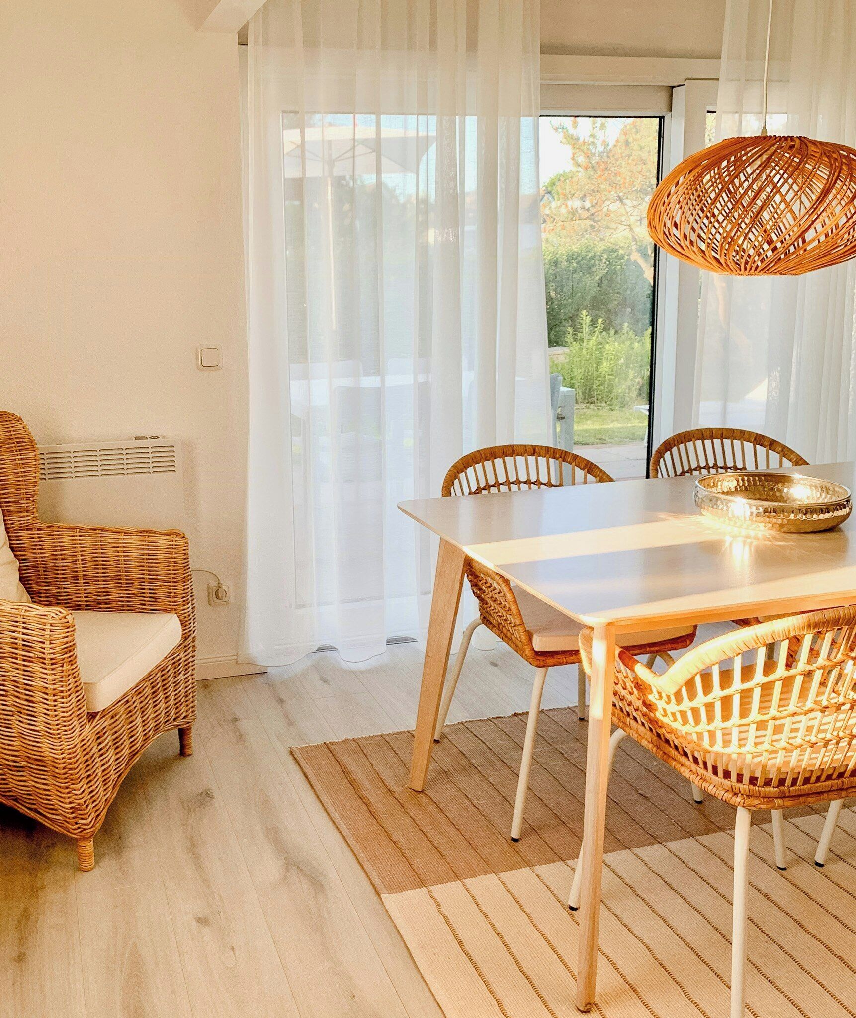 A dining area with a table, chairs, and a hanging light fixture.