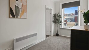 A room with a radiator, a door, a window with a view, and a potted plant. - Hobart CBD Loft - Walking to CBD (Hobart)