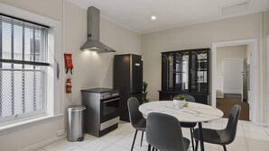 A modern kitchen with a built-in oven, a stainless steel range hood, and a black refrigerator. - Hobart CBD Loft - Walking to CBD (Hobart)