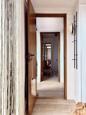 A wooden door leading to a room with a chair and a coat rack. - Beach villa overlooking South Funen Archipelago (Faaborg)