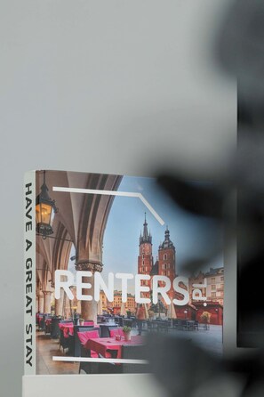 A book cover with a cityscape and a table with red tablecloths. - Cozy Apartment | Near the Banksy Museum (Kraków)