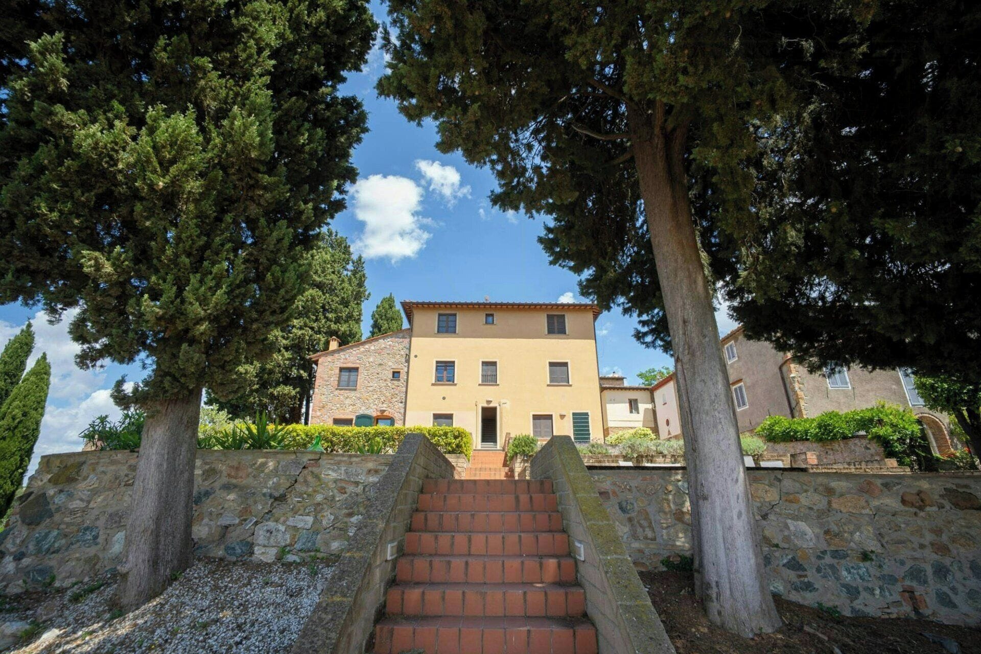 A building with a stone facade, a central entrance, and a staircase leading up to it.