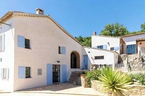 A white building with blue shutters, a stone staircase, and a small garden area. - 17th century Provençal farmhouse with pool (Le Plan de la Tour)