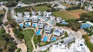 An aerial view of a residential area with modern houses, swimming pools, and green spaces. - Lombardi Villa Protaras (Protaras)