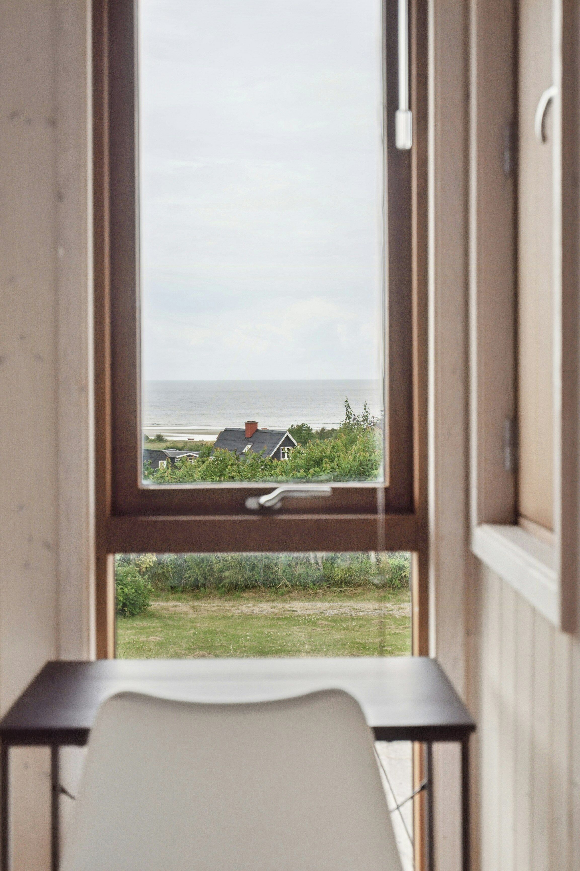 Une pièce avec vue sur la mer, une table et une chaise.