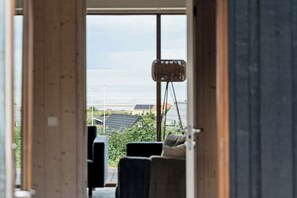 A room with a view of the sea, a wicker chair, and a sofa. - Seaside cottage at Bønnerup Strand (Glesborg)
