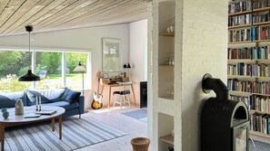 Ein gemütliches Wohnzimmer mit einer Couch, einem Tisch, einer Gitarre und einem Kamin.