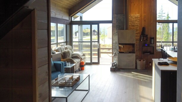 Un amplio salón con sofá, mesa de centro y chimenea.