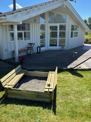 Una casa con una veranda, un aiuola rialzata e un’area patio.