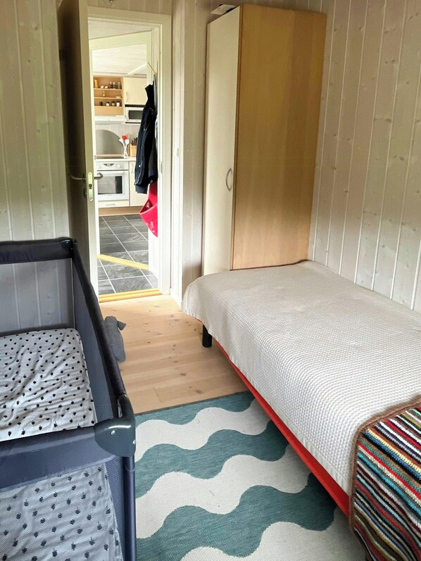 A compact room with a bed, a small table, and a wardrobe. - Family retreat by Roskilde Fjord (Ølsted)