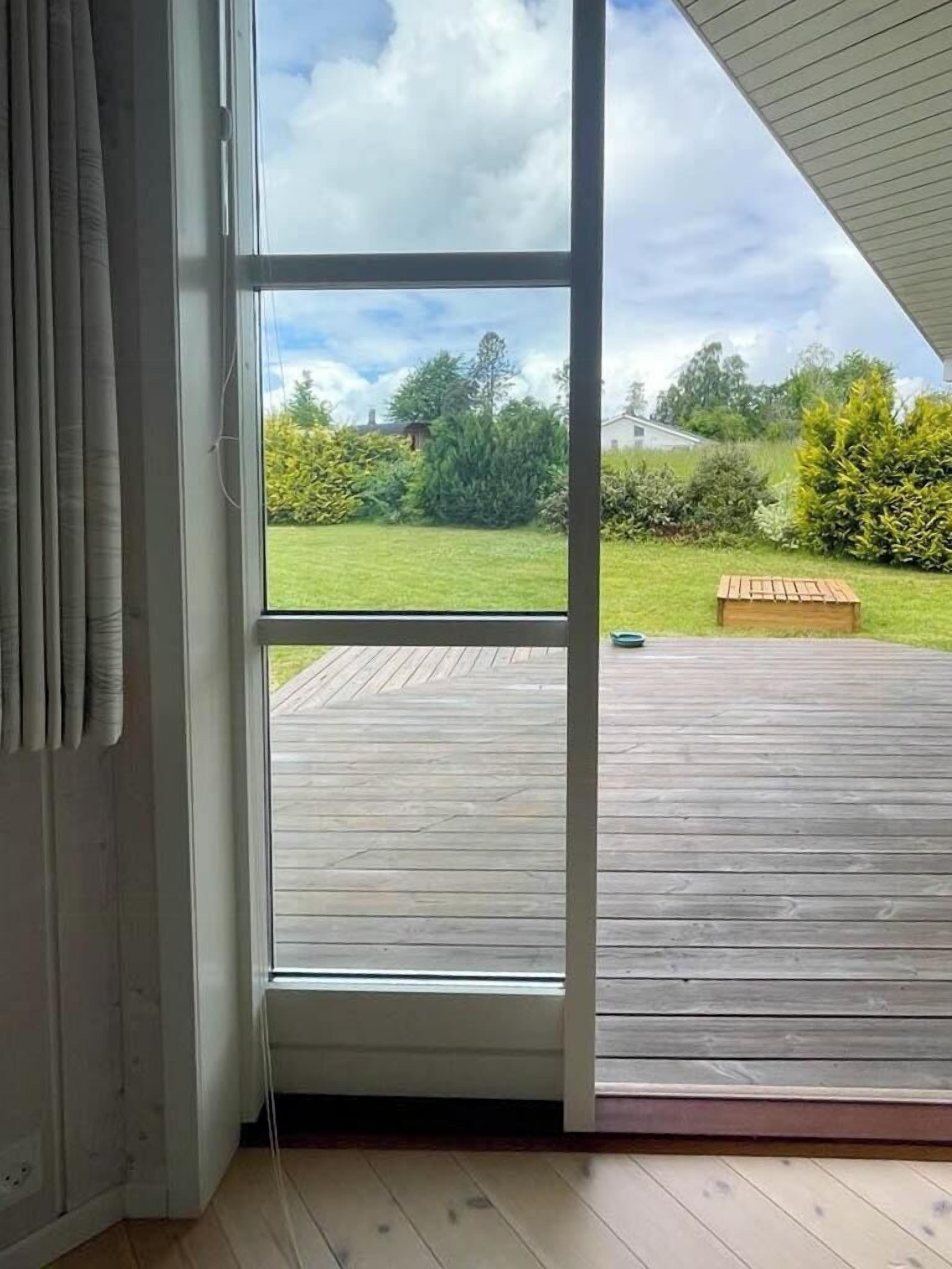 A room with a large sliding glass door leading to an outdoor deck.