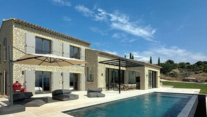A two-story stone house with a swimming pool, outdoor seating, and a covered patio. - Villa with panoramic views and pool in Gordes (Gordes)