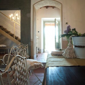 Ein Schlafzimmer mit Bett, Sessel, Treppe und Blick ins Freie.