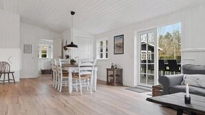 Una habitación amplia con comedor, sofá y un gran ventanal.