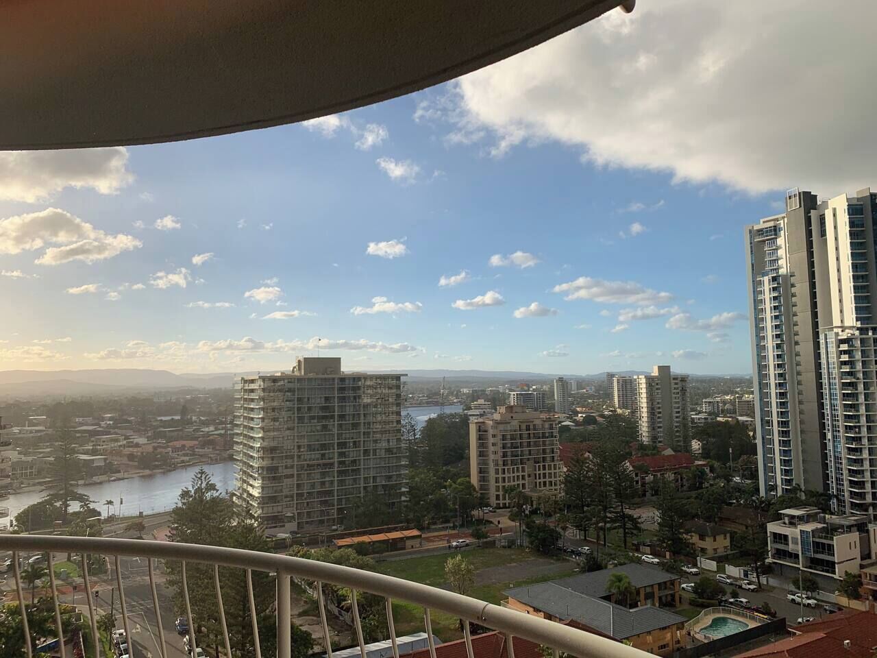 Une vue urbaine avec de hauts immeubles, une rivière et un ciel dégagé.