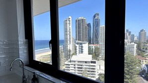 A bathroom with a large window, a sink, and a bottle of soap. - Beachside Escape, VIEWS all around, steps to beach (Surfers Paradise)