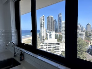 A bathroom with a large window, a sink, and a bottle of soap. - Beachside Escape, VIEWS all around, steps to beach (Surfers Paradise)