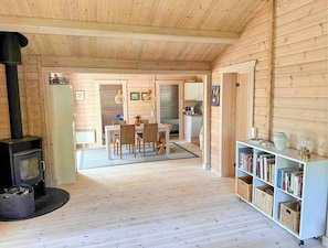 Ein Holzinnenraum mit Kamin, Essbereich und Bücherregal.