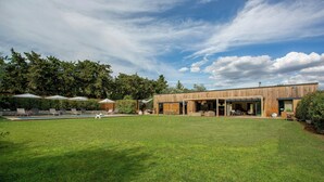 Un bâtiment moderne doté d’une grande pelouse, d’un espace extérieur aménagé et d’une piscine.