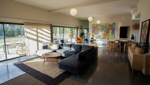 Un salon moderne comprenant un canapé d’angle, une table basse et un coin repas avec une table et des chaises.