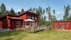 Un edificio rojo con terraza y zona de estar al aire libre.