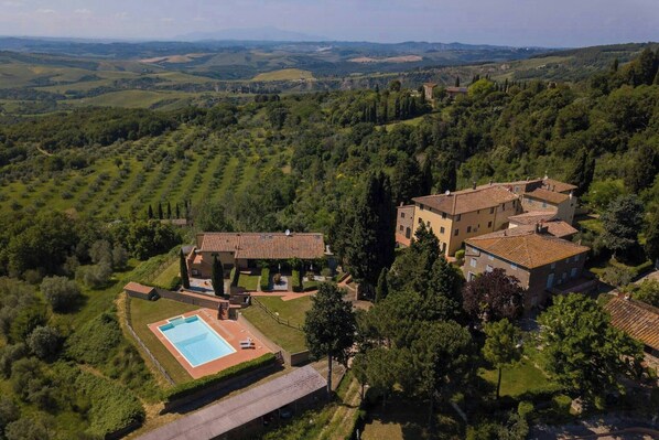 A villa with a swimming pool, surrounded by lush greenery and hills. - Tuscan apartment with panoramic views in Iano (Montaione FI)